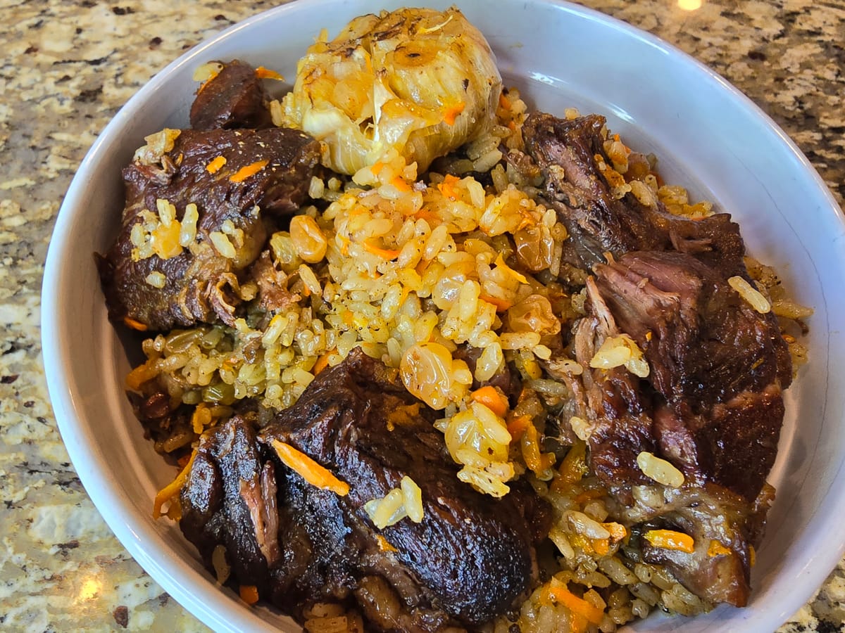 Golden beef plov with tender meat, fluffy rice, and caramelized onions in a serving bowl