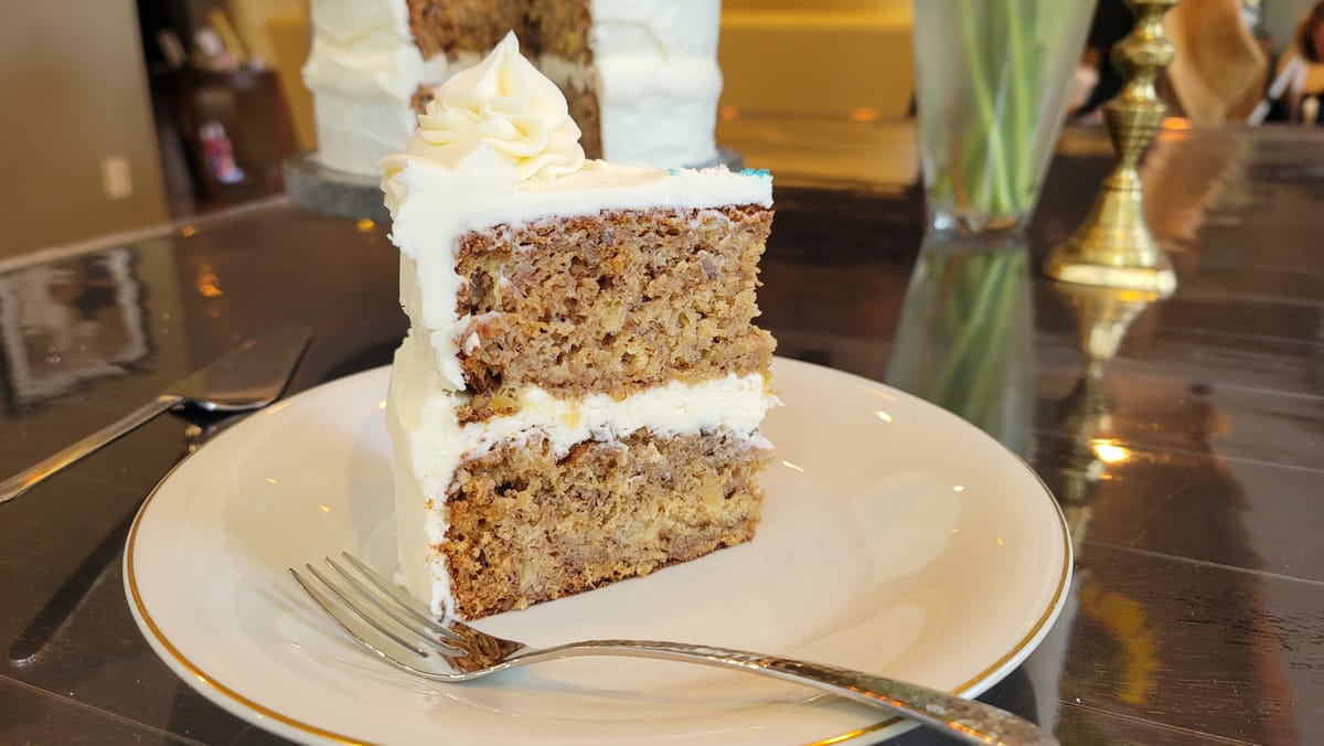 Hummingbird cake with cream cheese frosting, featuring spiced banana and pineapple layers on a white plate
