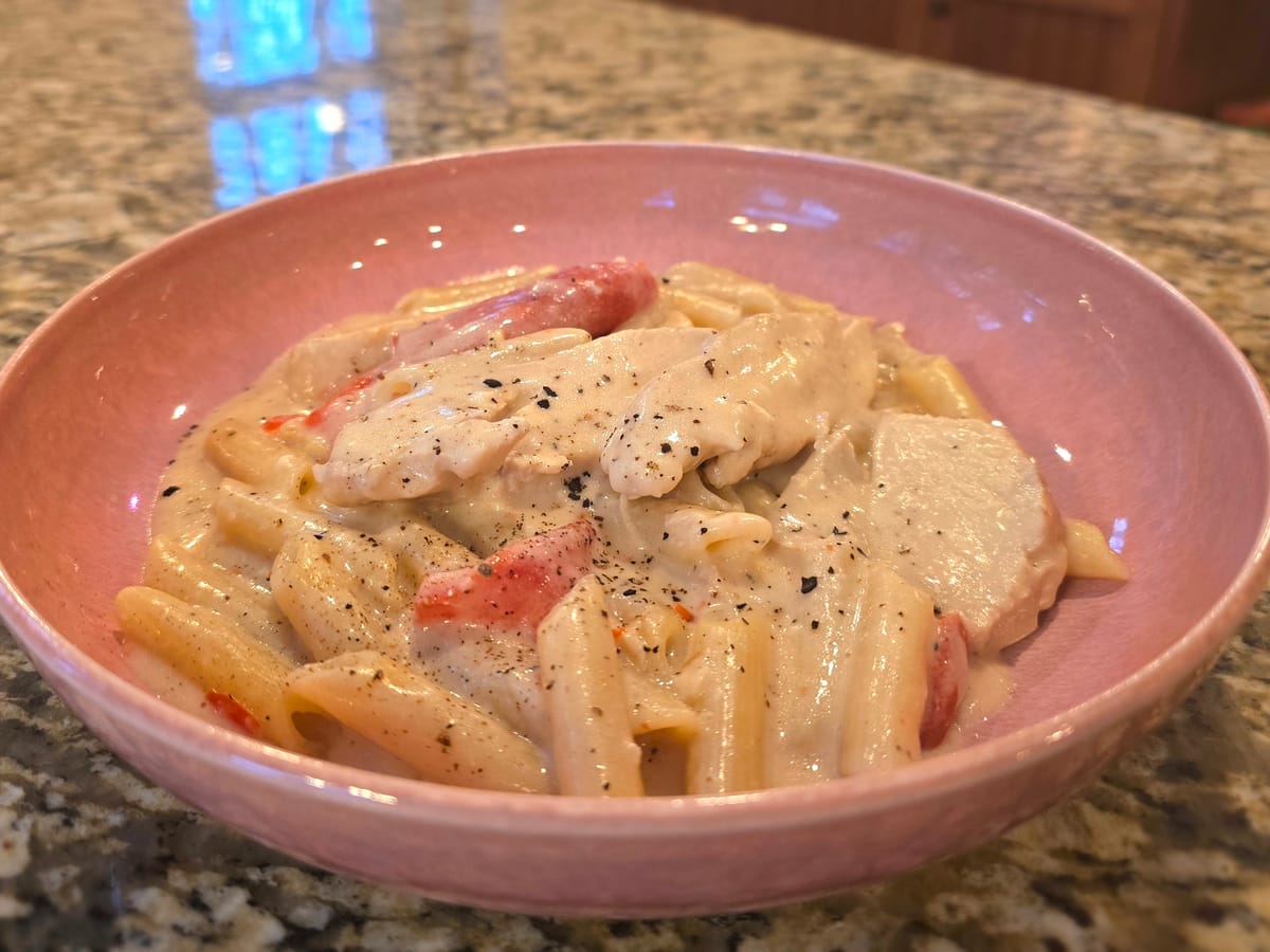 Creamy chicken alfredo pasta with tender chicken pieces and silky sauce on a white plate