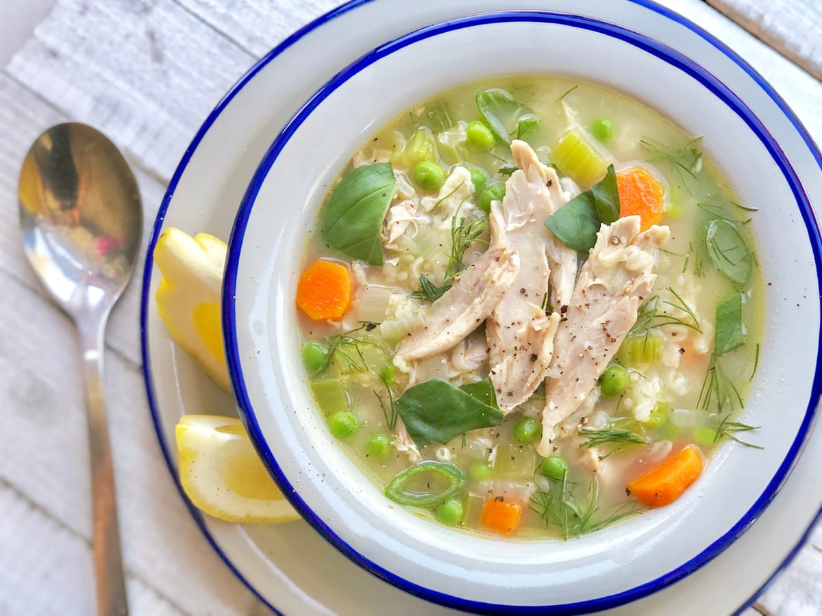 Bowl of hearty brown rice chicken soup with tender chicken pieces, brown rice, and vegetables in a clear broth