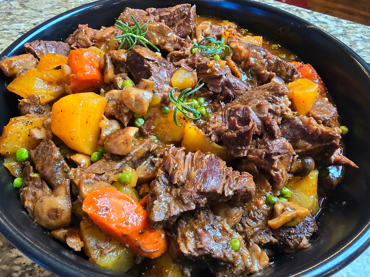Bowl of tender beef stew with chunks of beef, carrots, celery, and onions in a rich brown gravy