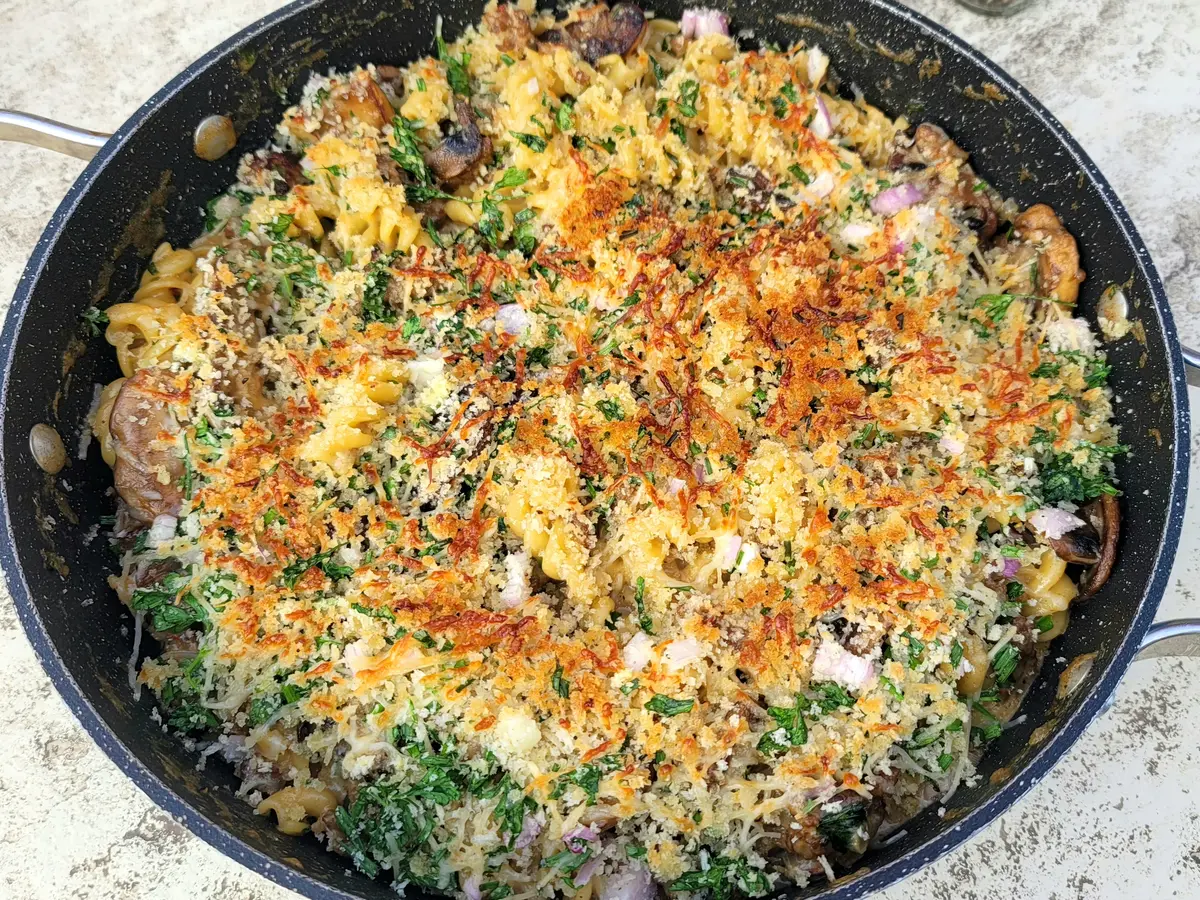 Creamy sausage mushroom bake in a baking dish with melted cheese and fresh herbs, golden and bubbly