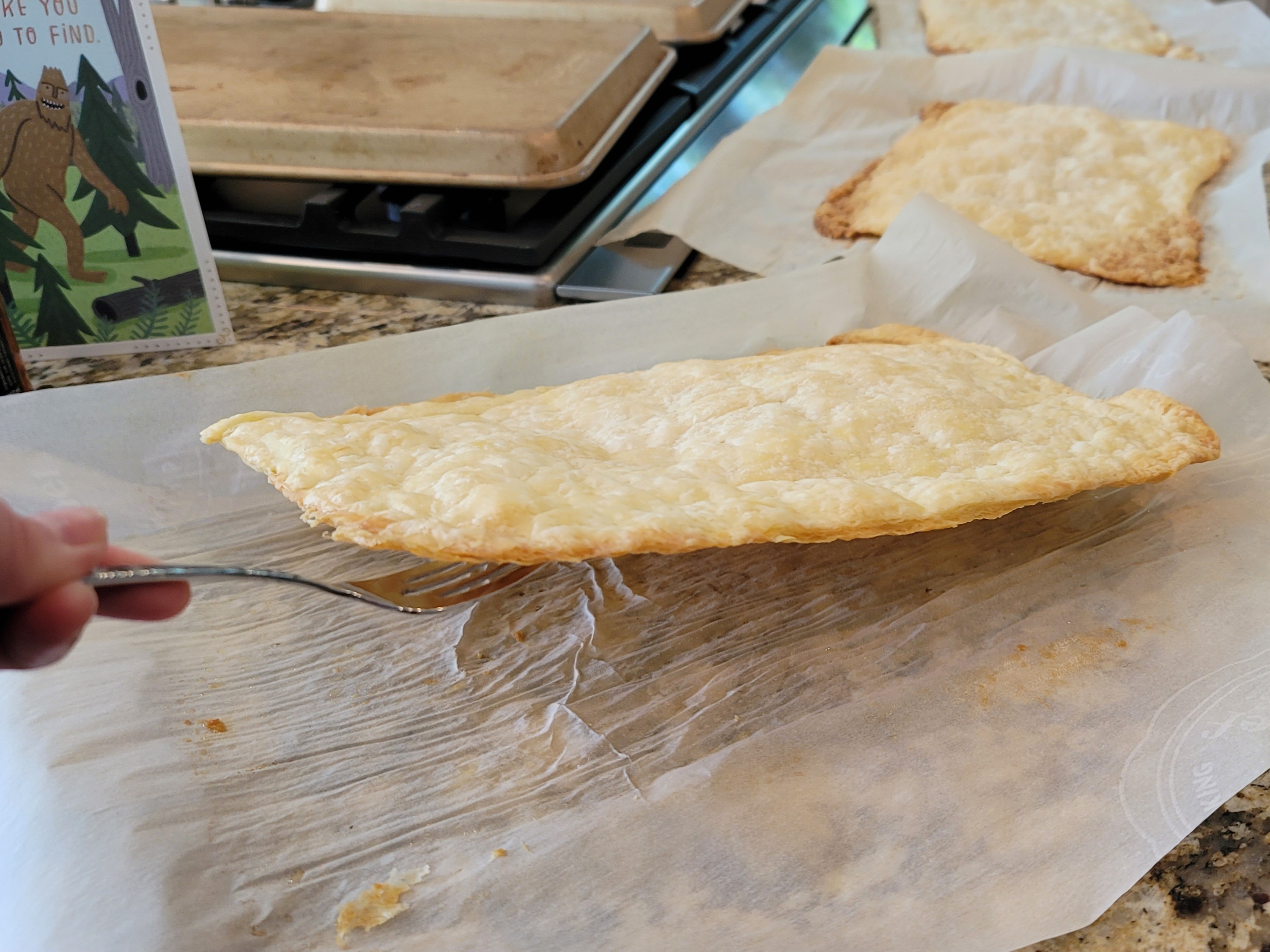 Golden-brown homemade puff pastry sheets with flaky, layered texture stacked on a light surface