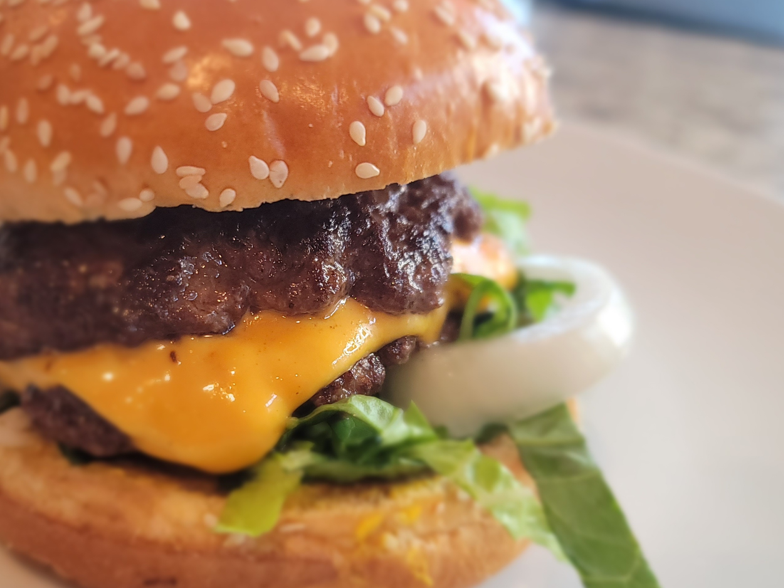 Crispy smashed Jucy Lucy burger on toasted bun with melted cheese visible inside the beef patty